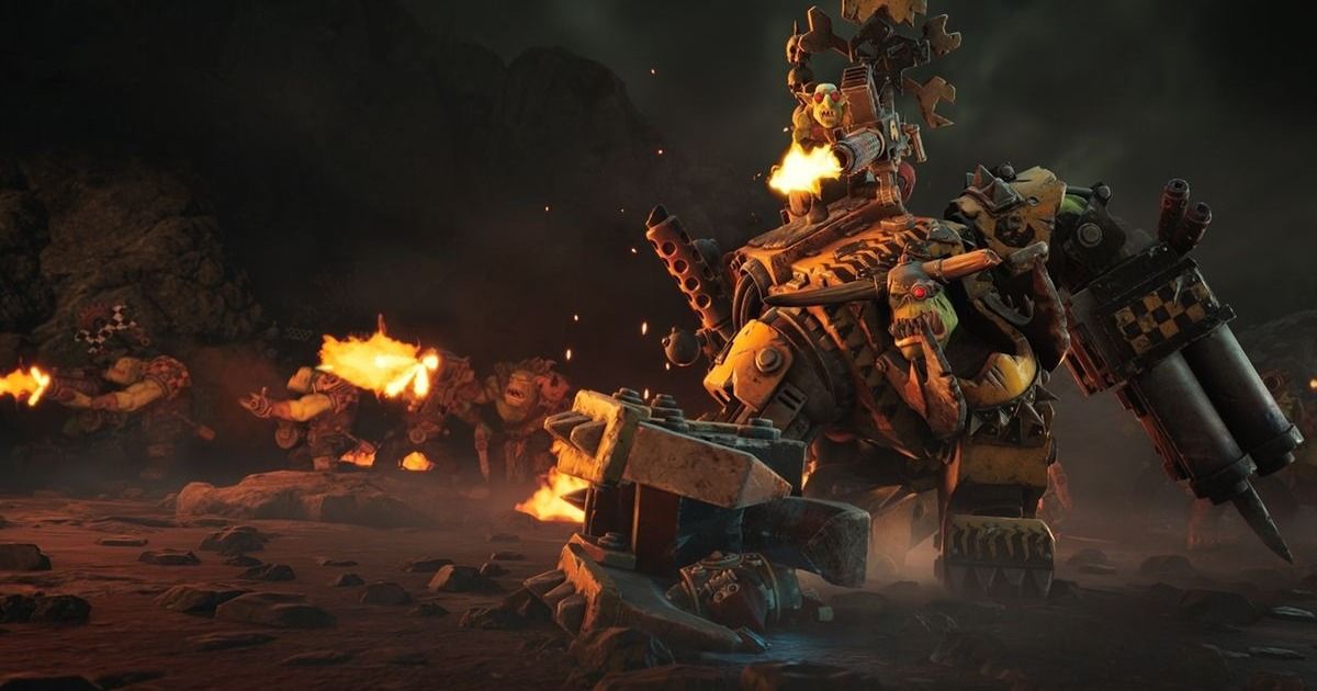 Un massiccio veicolo da combattimento degli Ork avanza tra fiamme e macerie in una scena di gioco